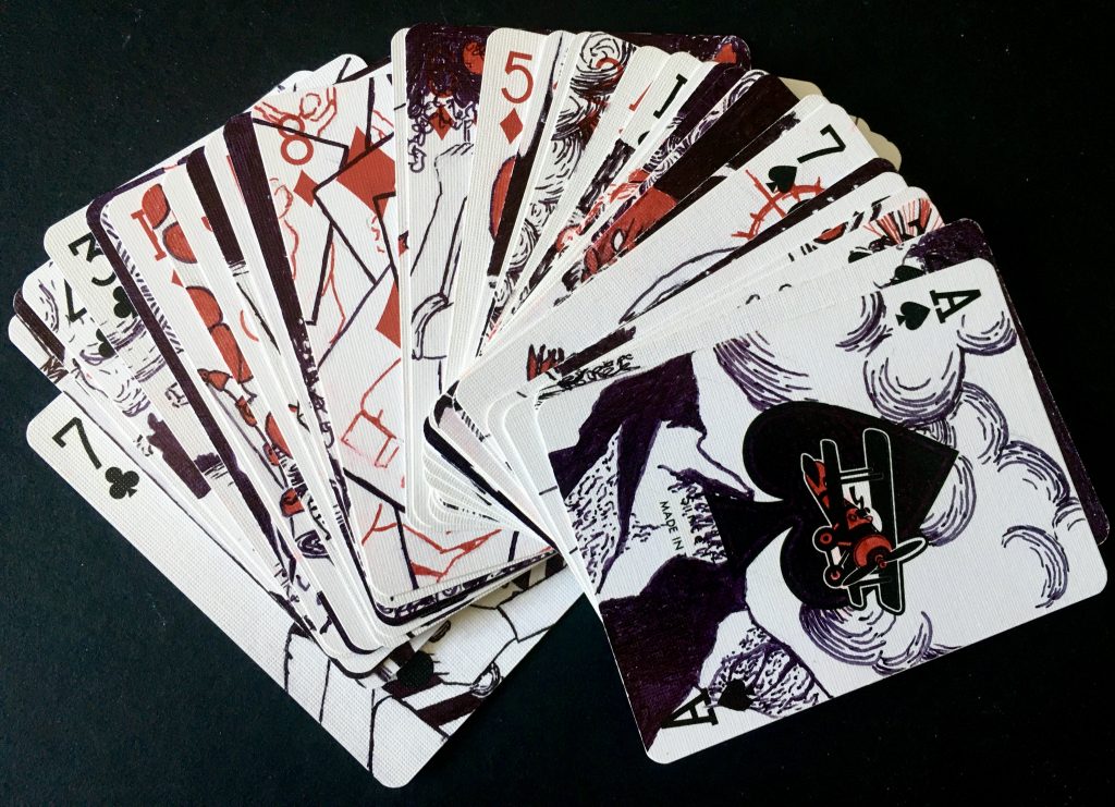 A fanned-out deck of playing cards decorated with red and black drawings.