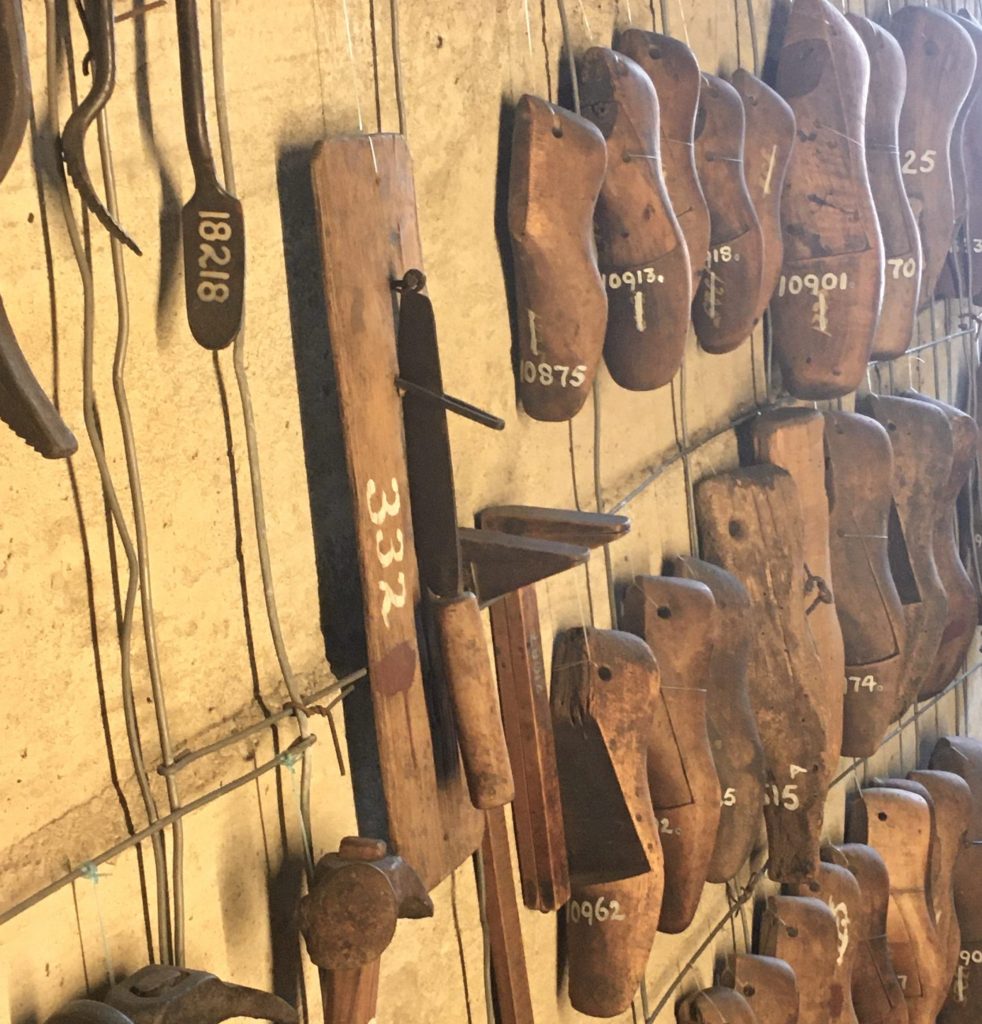 A wall hung with shoe-forms and other cobbling tools